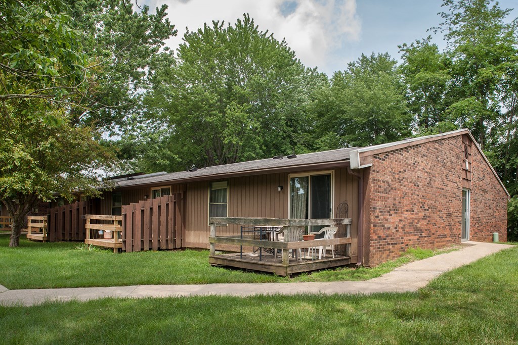 a house with a porch and a deck in the grass