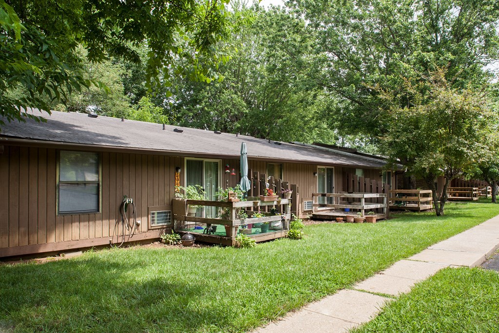 a house with a porch and a yard with grass and trees