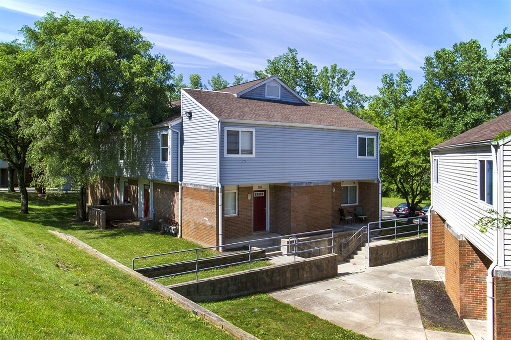 the front of a house with a yard and a sidewalk