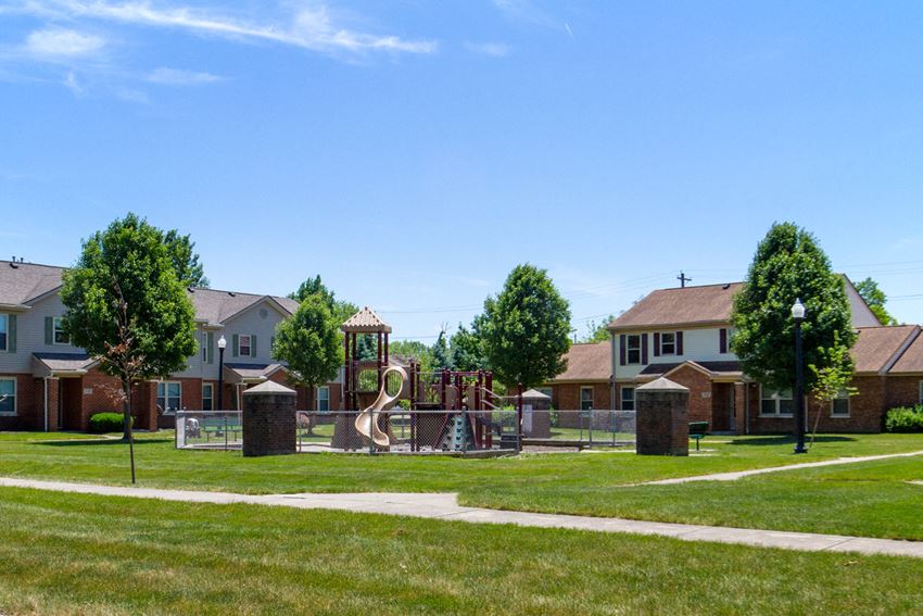 a park with a playground and houses in the background