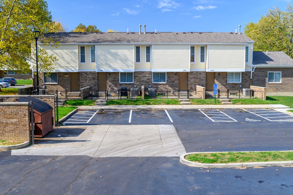 an empty parking lot in front of an apartment building