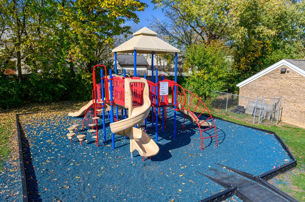 a playground with a swing set and slides in a backyard