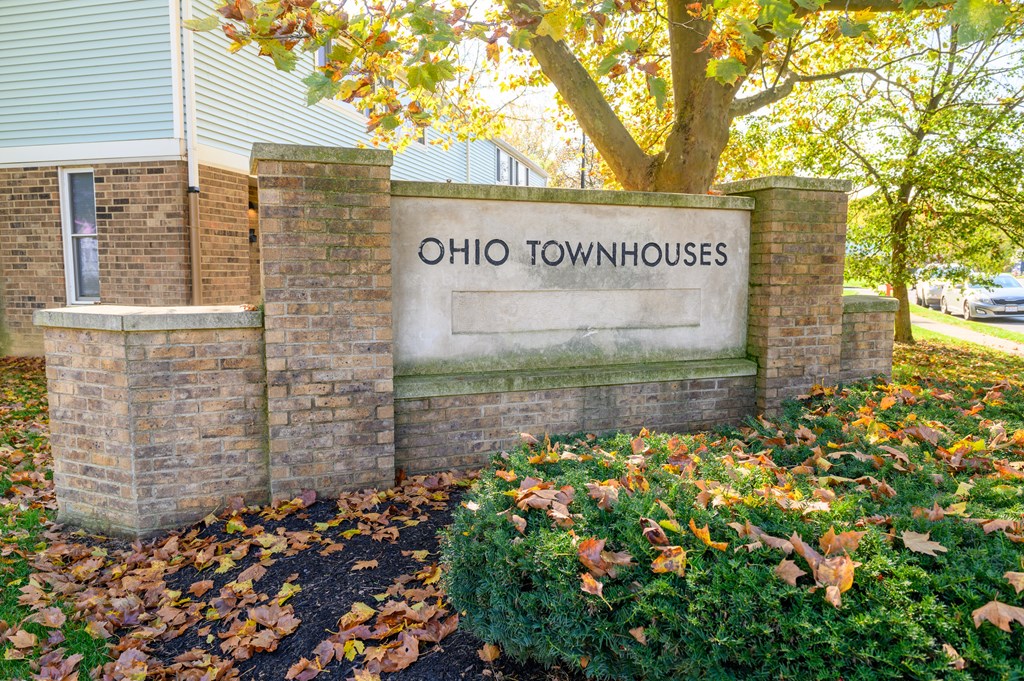 a sign townhouses in front of a tree
