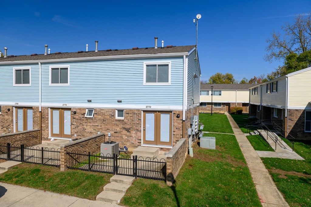 a blue house with a brick building and a sidewalk