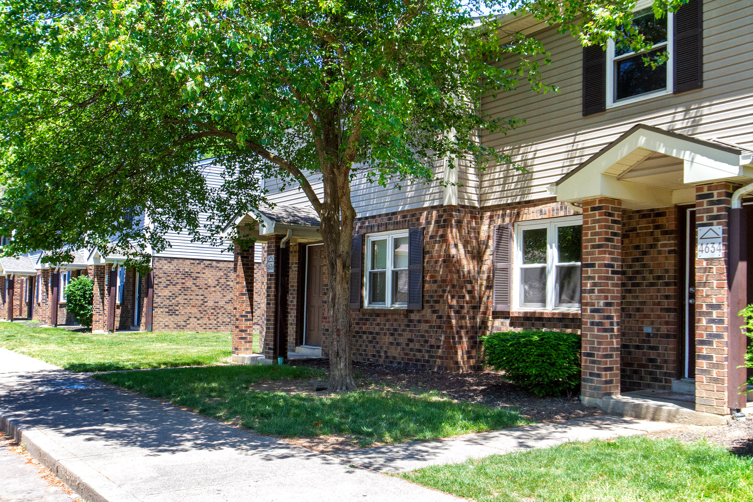 a brick house with a tree in front of it