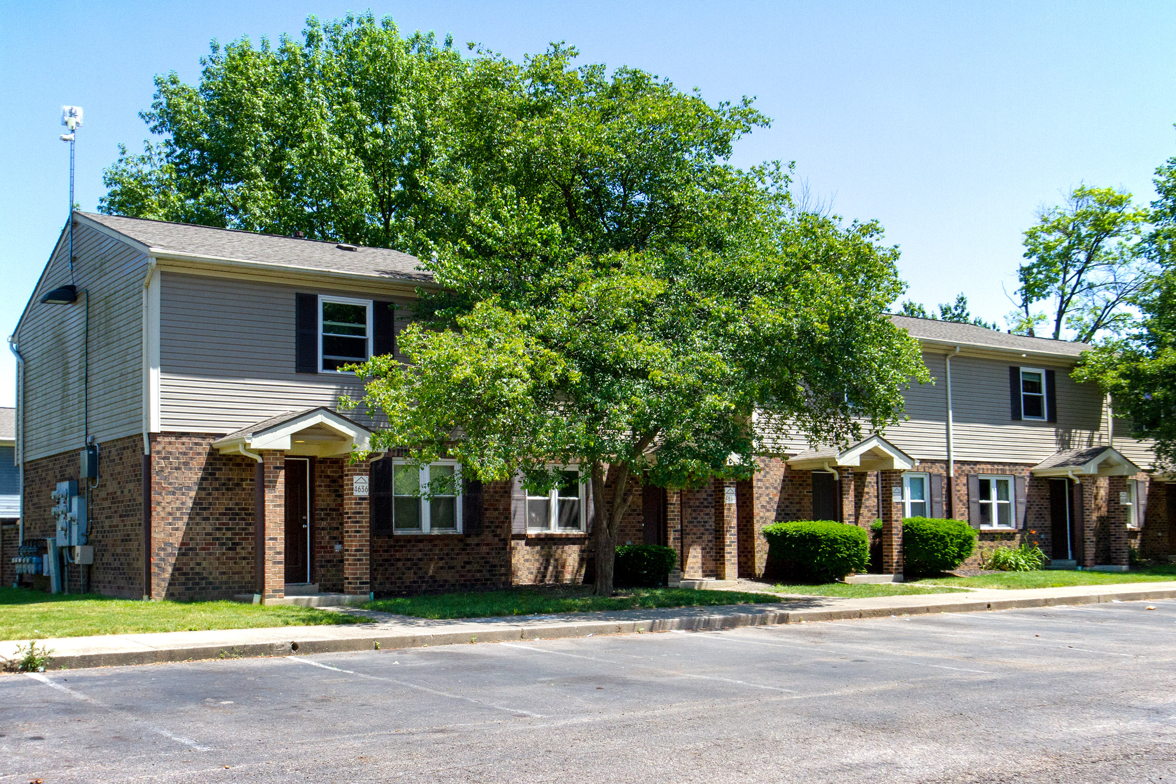 an apartment building with a tree in front of it