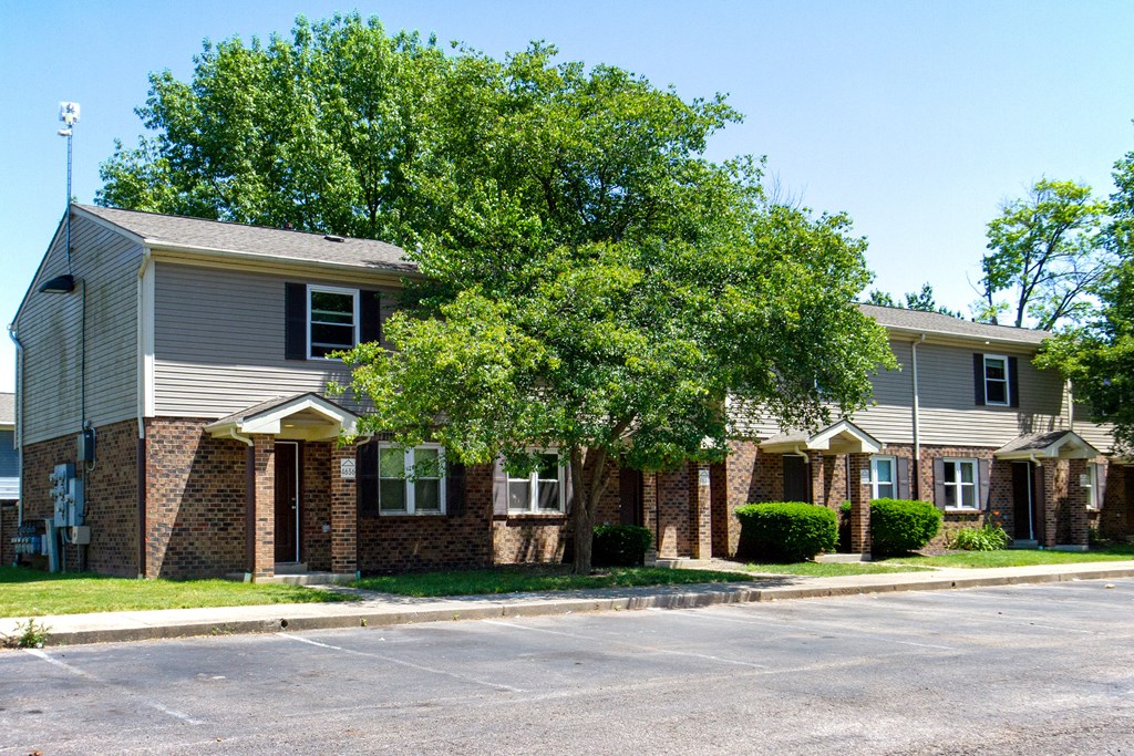 an apartment building with a tree in front of it