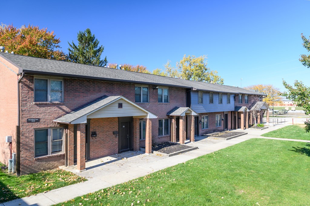 exterior view of a brick apartment building with a sidewalk