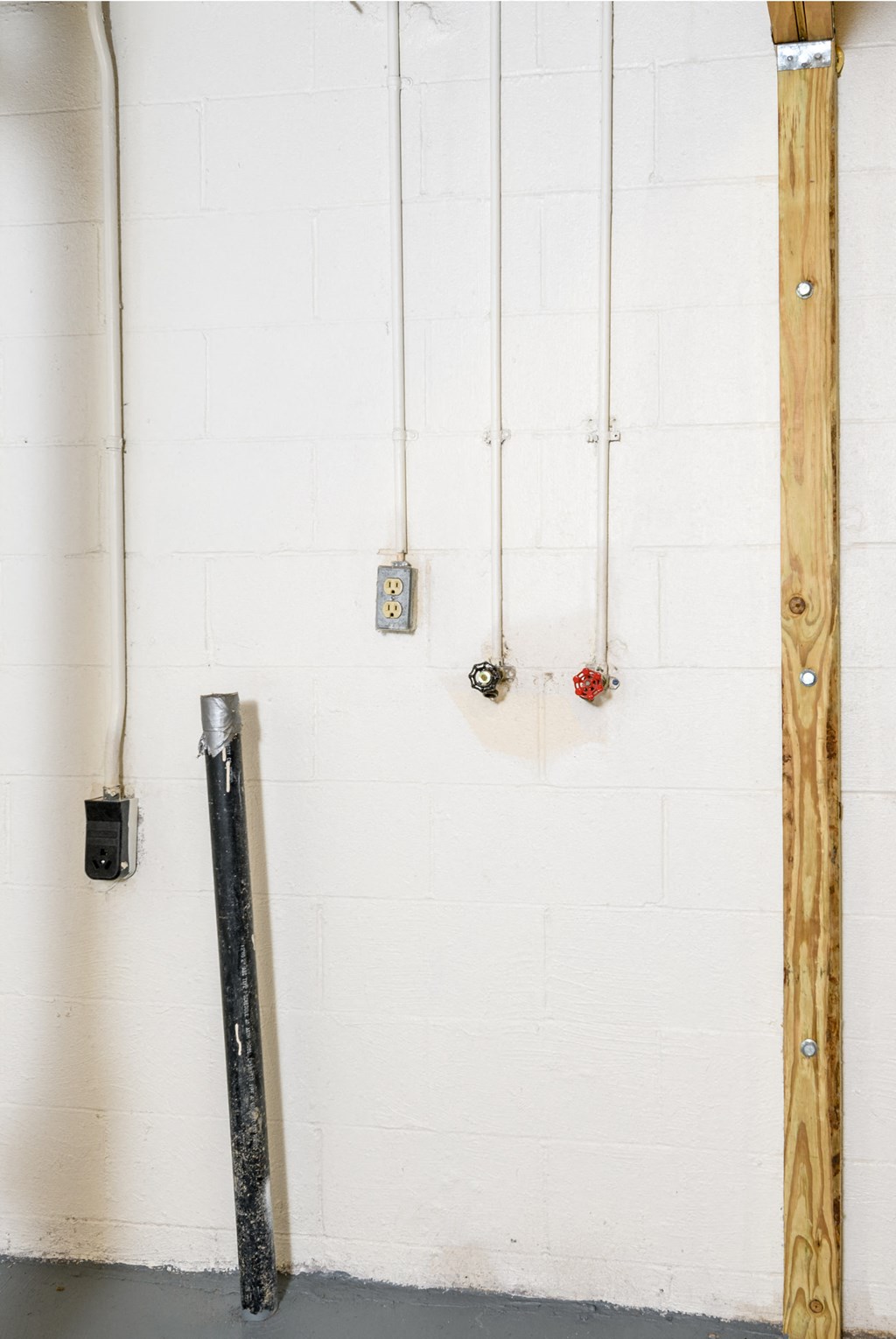 a white brick wall with a wooden frame and hooks on the wall
