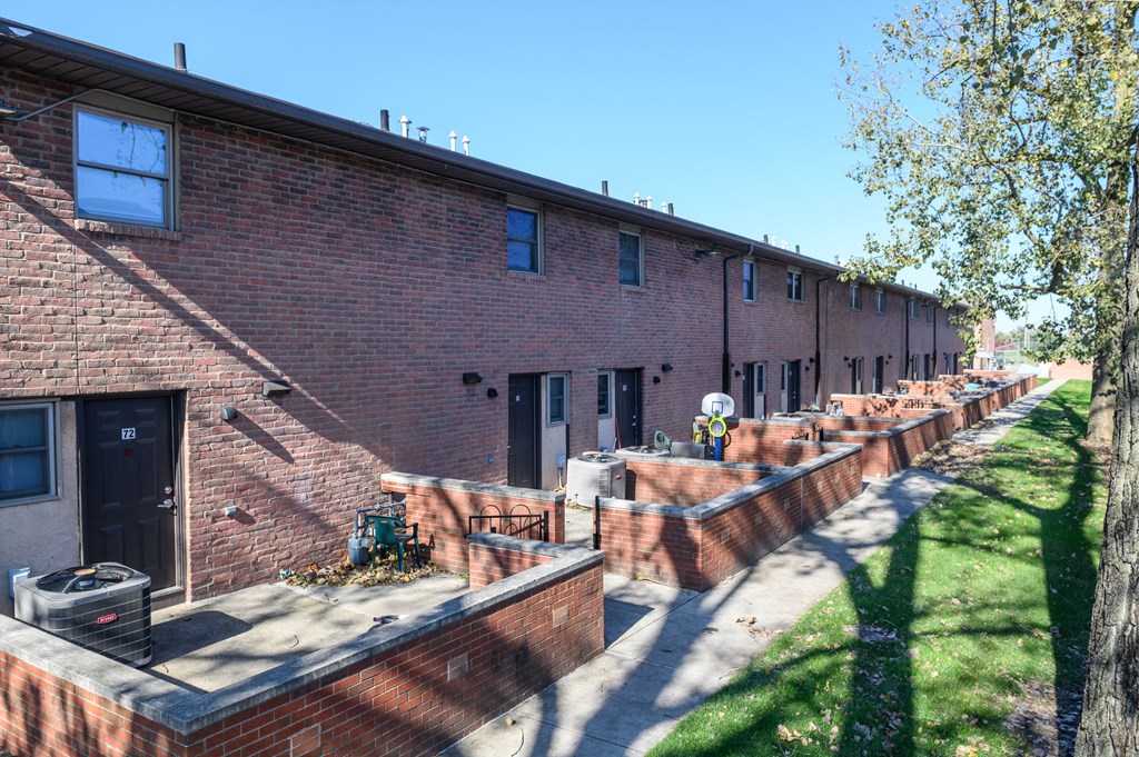 a row of brick apartment buildings with brick retaining walls