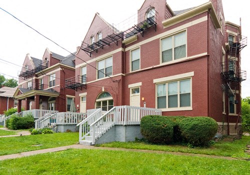 a red brick apartment building with a white staircase