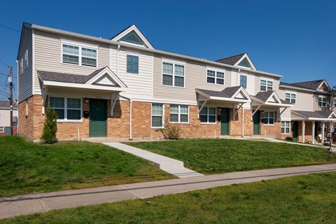 an apartment building with a sidewalk in front of it