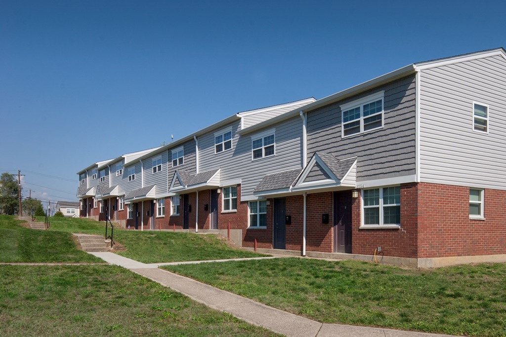 a row of houses on the side of a sidewalk