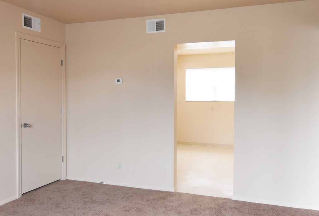 an empty room with a door and a window