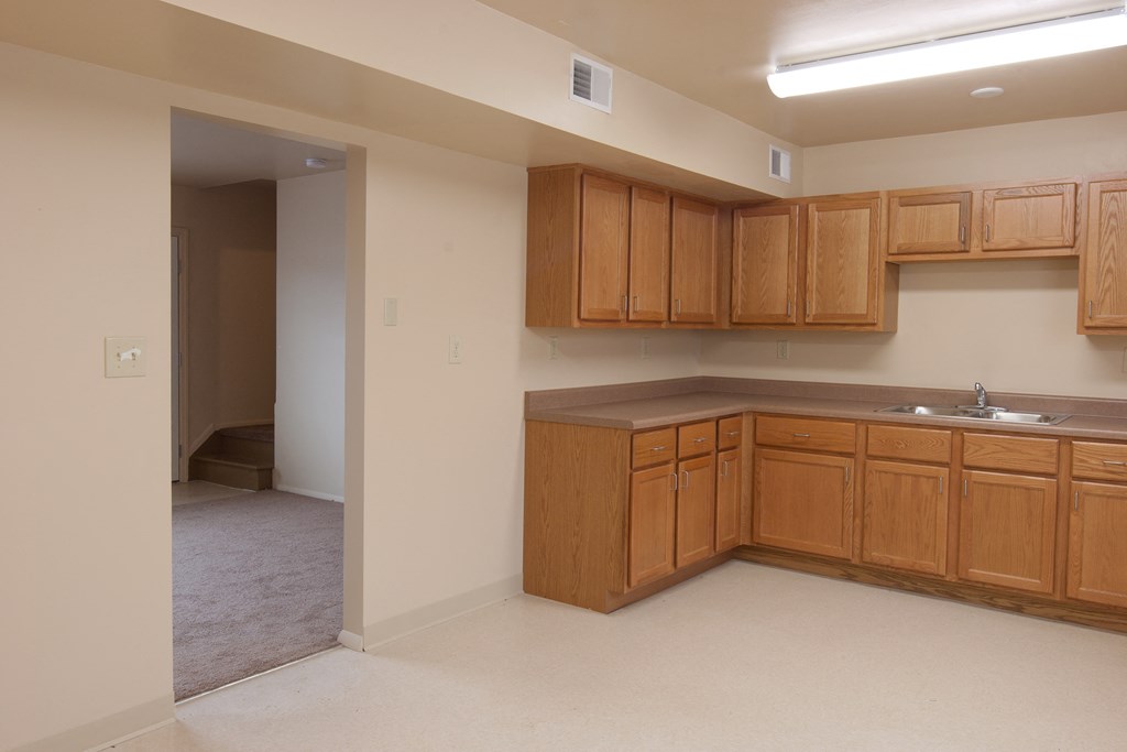 an empty kitchen with wooden cabinets and a sink