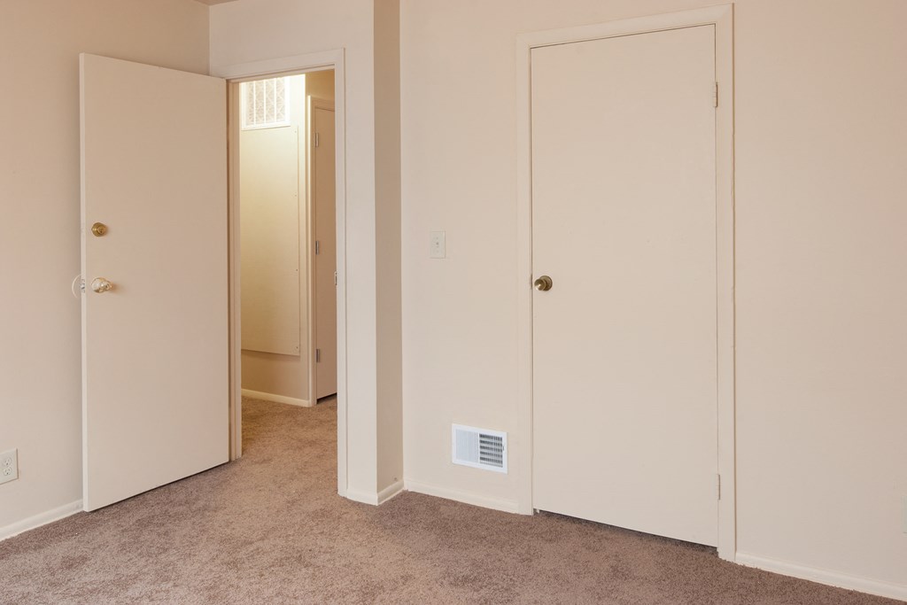 a bedroom with two closets and a door to a hallway