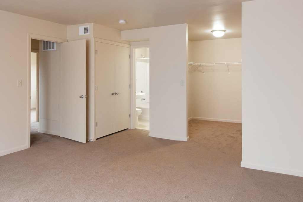 an empty living room with an open door to a bathroom