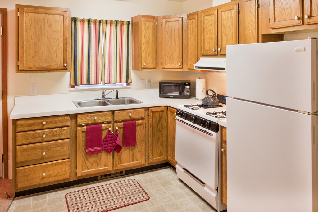 a kitchen with white appliances and wooden cabinets