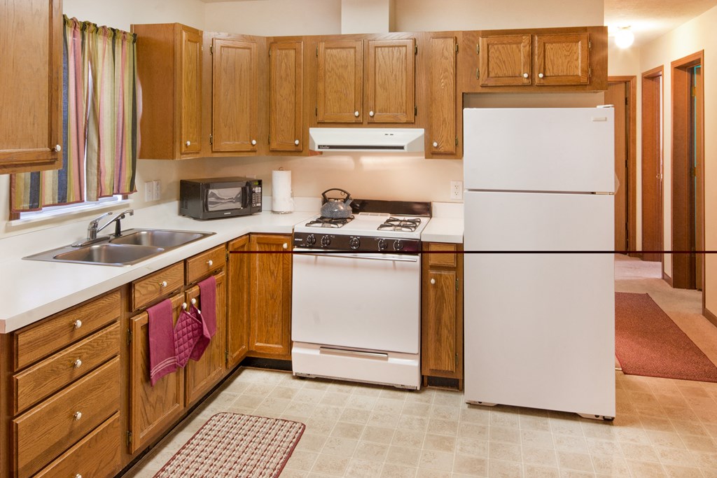 a kitchen with white appliances and wooden cabinets