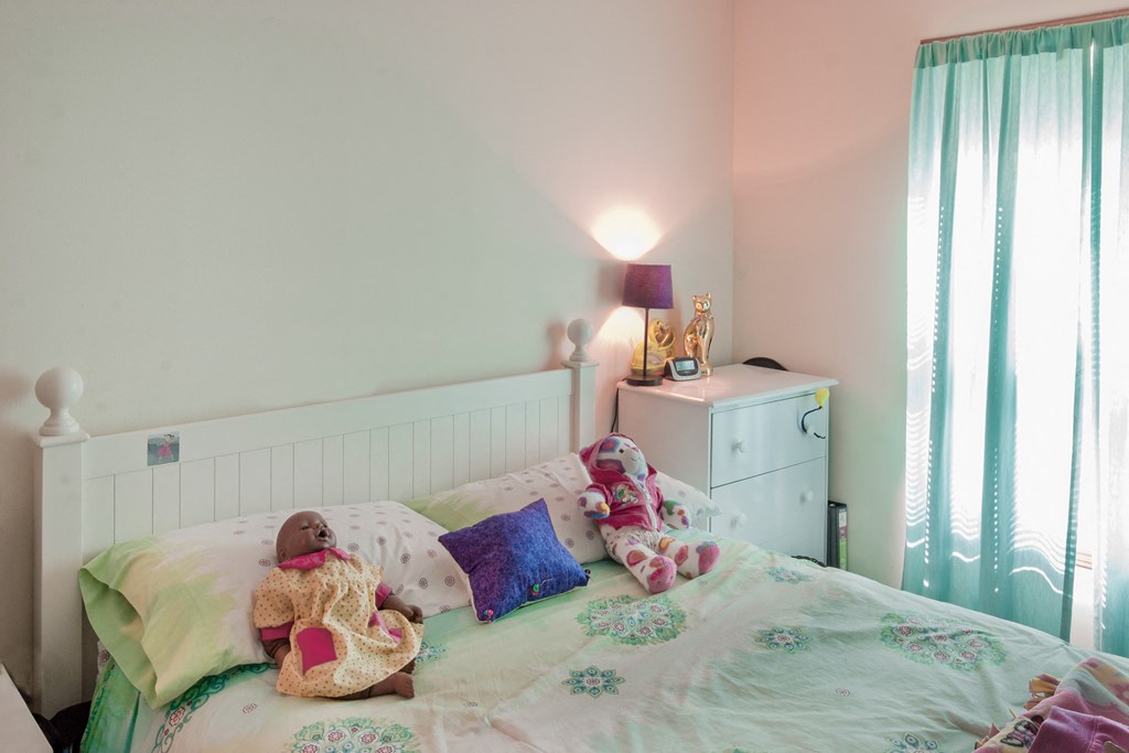 a bedroom with a bed with stuffed animals on it