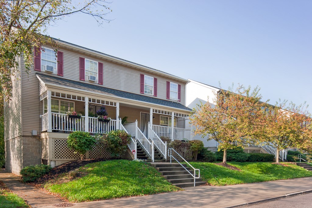 the front of a house with a porch and stairs