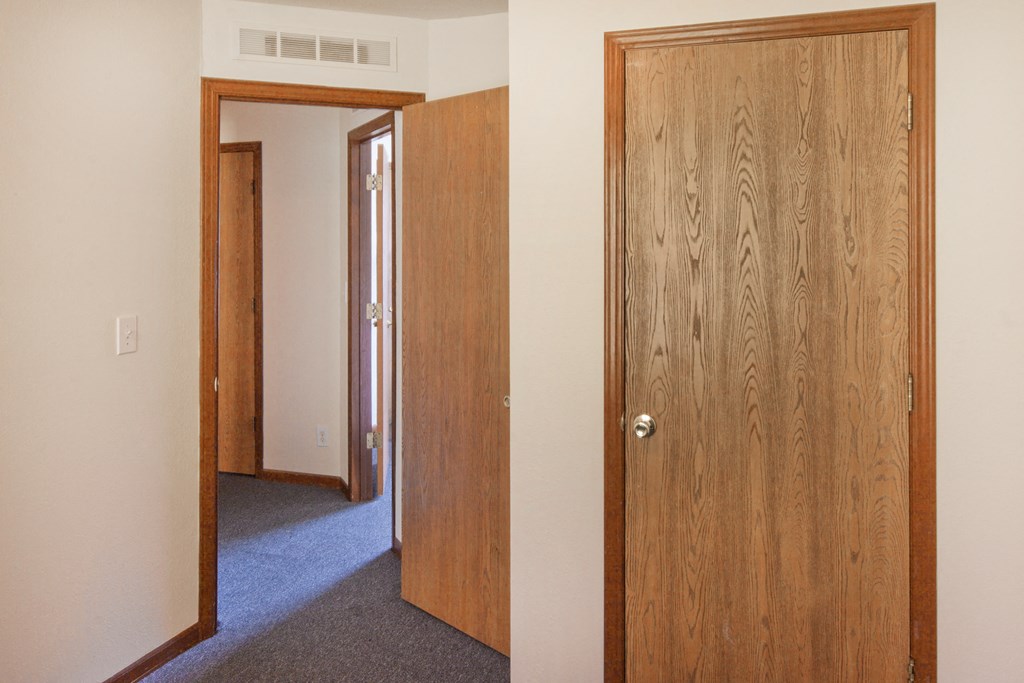 an open bedroom door and a hallway with a door to a bedroom and a closet
