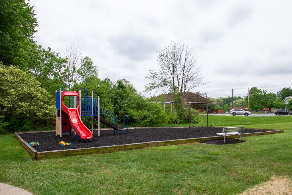 a playground with a slide and a picnic table in a yard