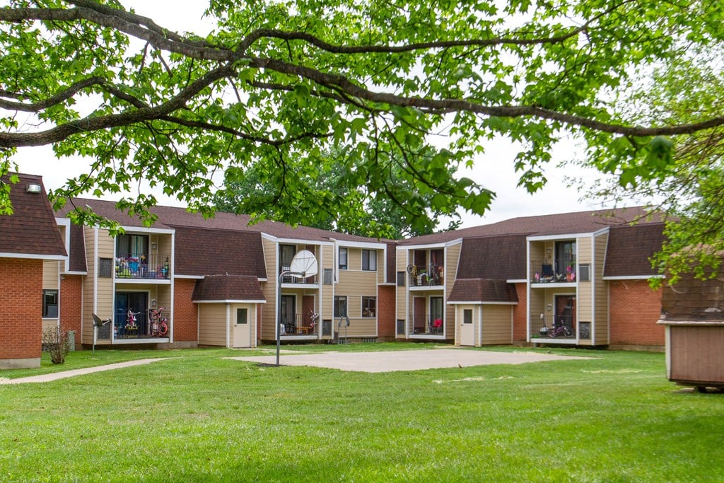 a group of apartments with a yard and green grass