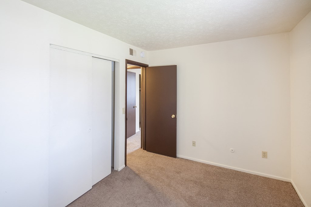 a bedroom with a closet and a door to a hallway