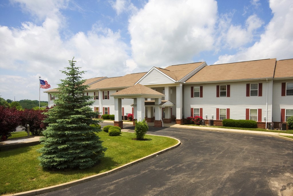 the view of a large white building with a tree in front of it