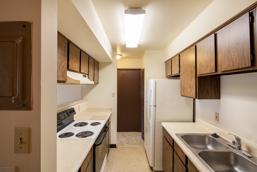 a kitchen with a stove and a refrigerator and a sink