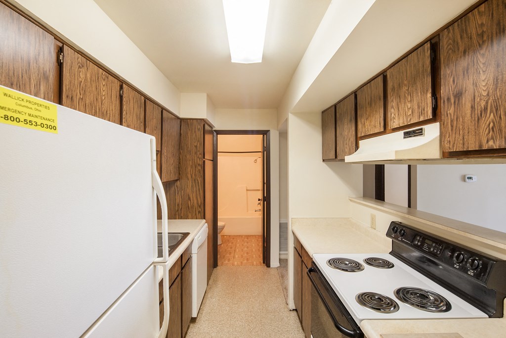 a kitchen with white appliances and wooden cabinets and a white refrigerator