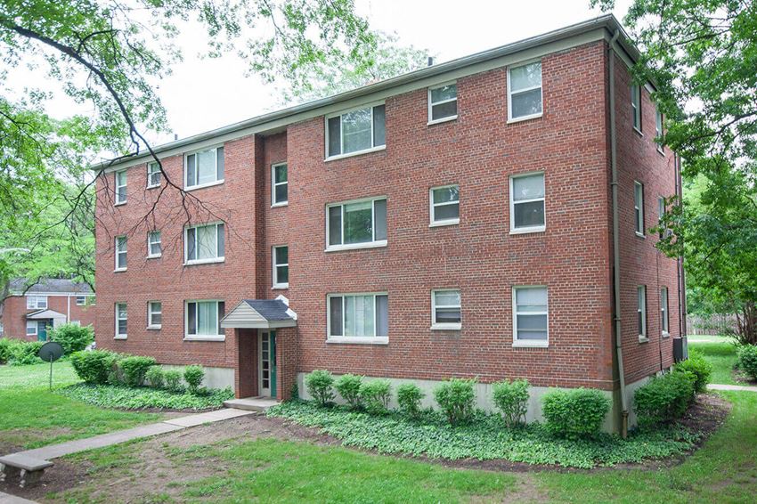 a brick apartment building with a sidewalk in front of it