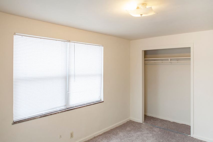 a bedroom with a large window and a closet