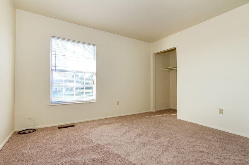 an empty room with carpet and a window
