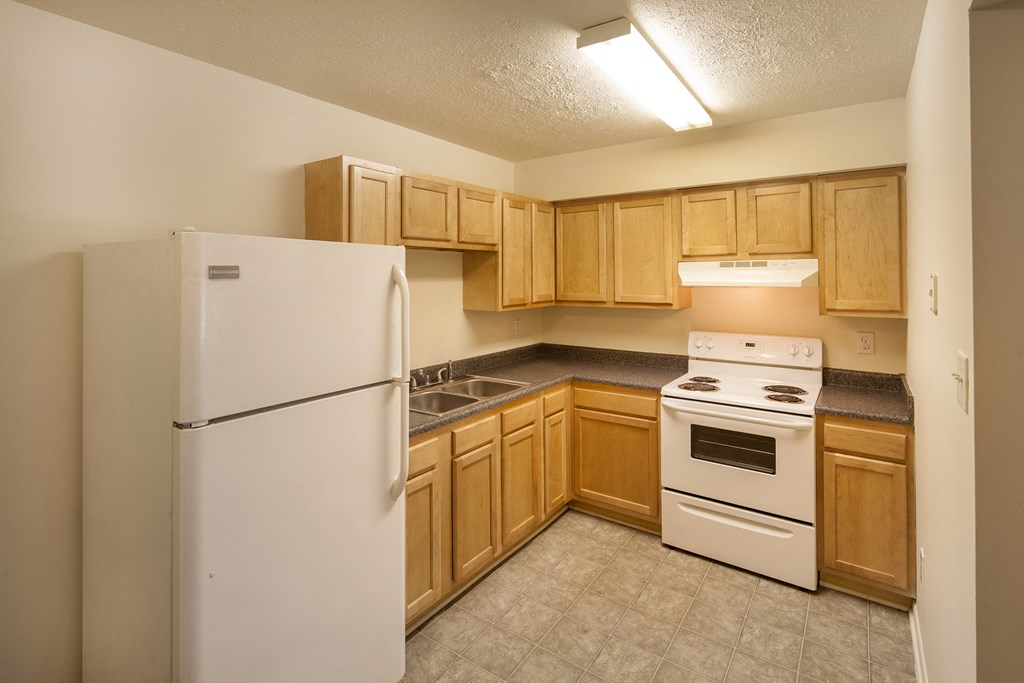 a kitchen with white appliances and wooden cabinets