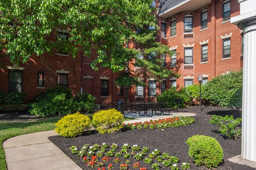 a courtyard with a picnic table in front of a brick building