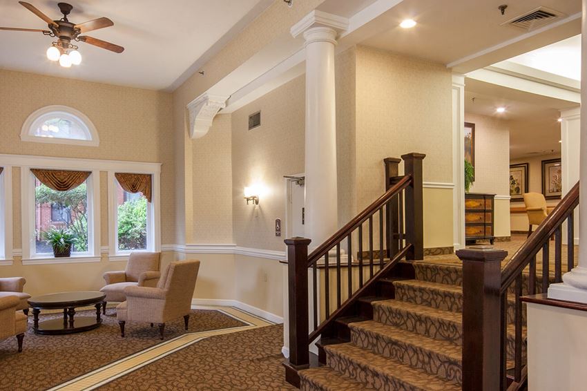 a lobby with a staircase and a living room with furniture