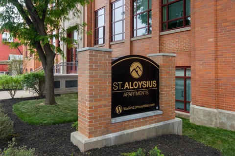 a sign apartments in front of a brick building