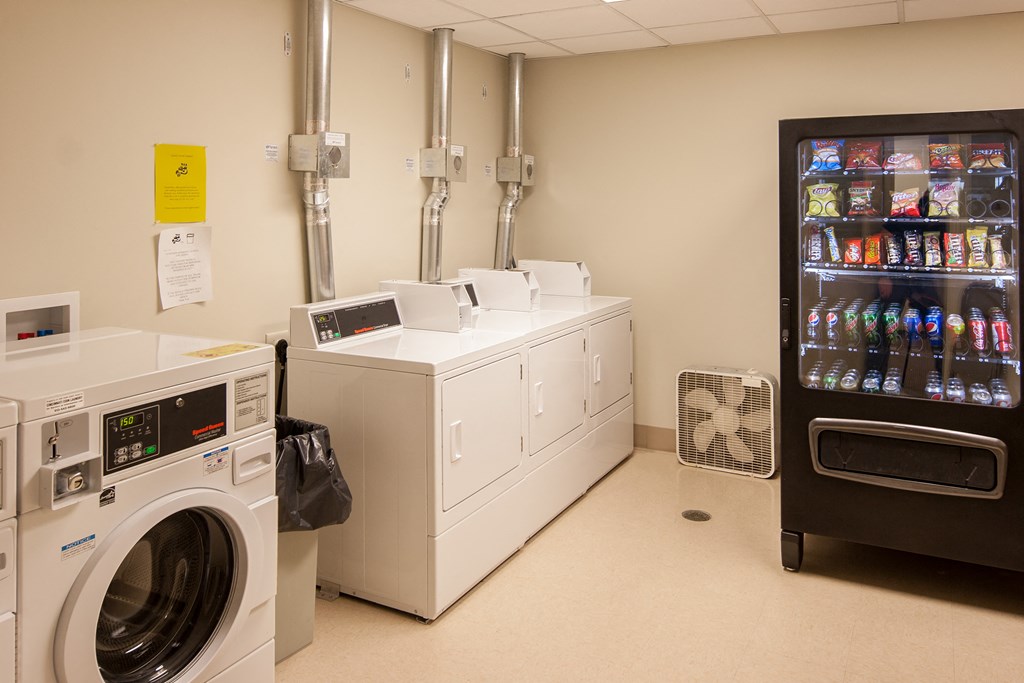 a laundry room with washer and dryers and a vending machine