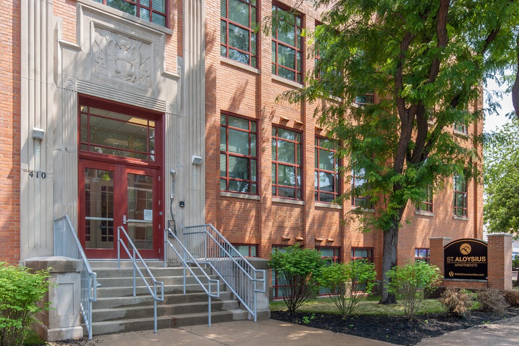 a large brick building with a red door and stairs