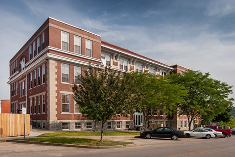 a large brick building with cars parked in front of it