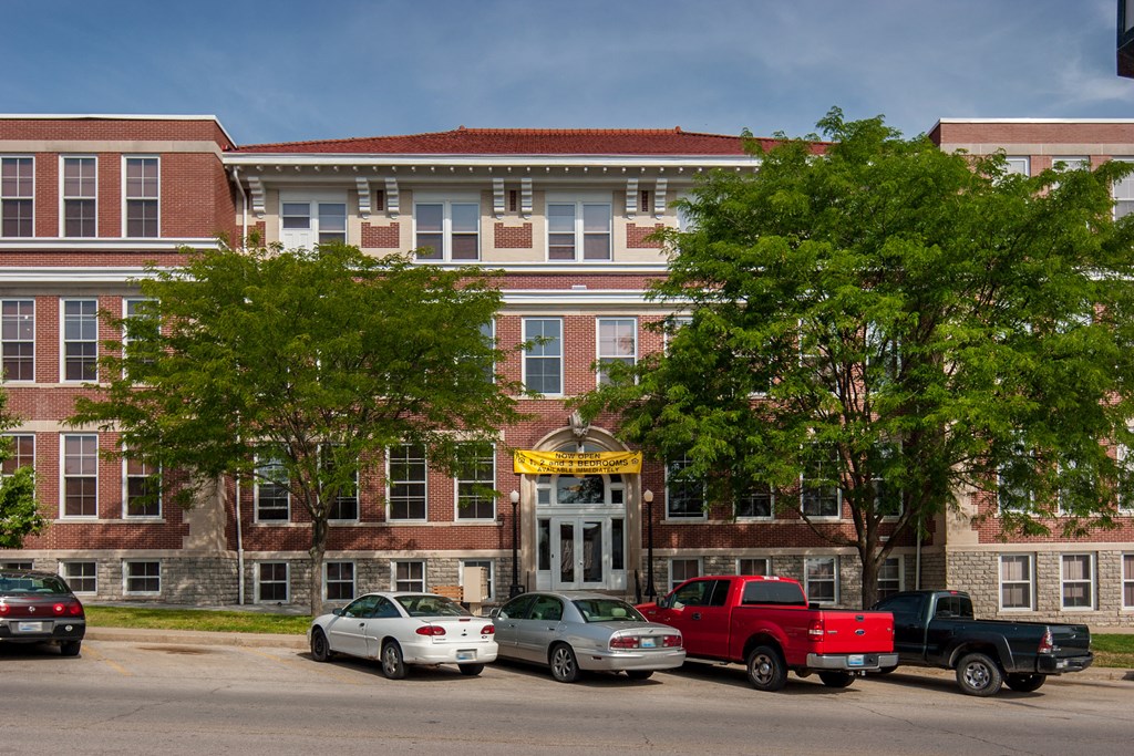 a large brick building with cars parked in front of it