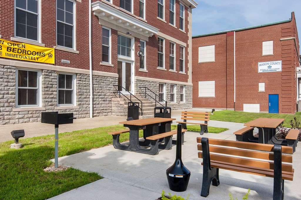 a sidewalk with benches in front of a brick building
