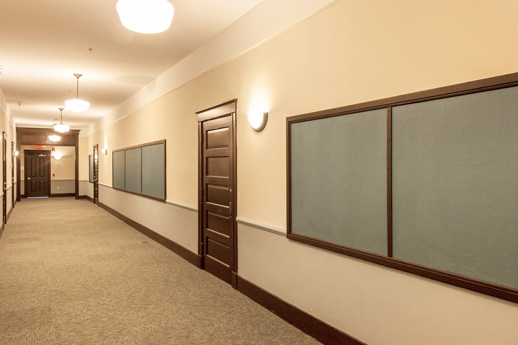 a hallway with a chalkboard and doors in a building