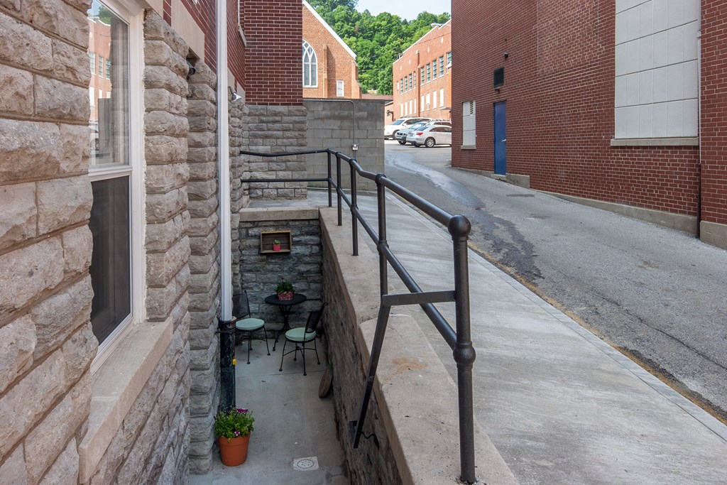 a small balcony with a metal railing next to a brick building