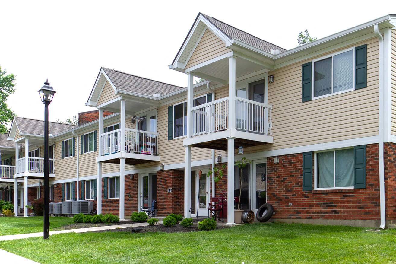 a row of homes with balconies and a lawn