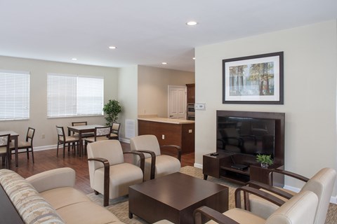 a living room and dining room with a television and a table and chairs