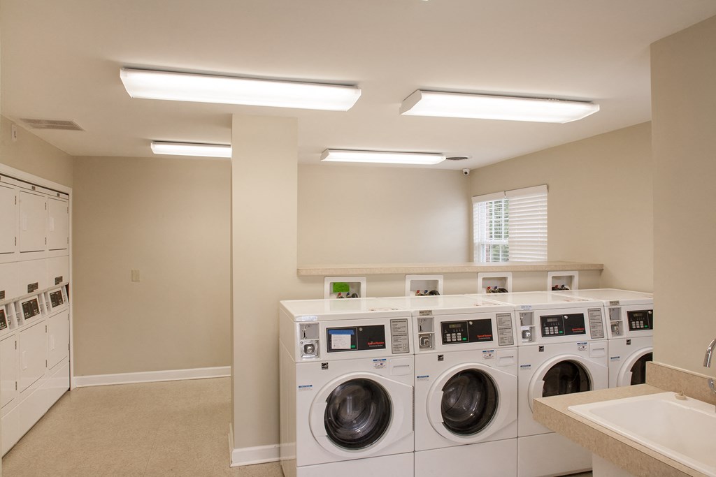 a washer and dryer in a laundry room with washing machines and a sink