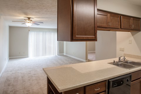 an empty kitchen and living room with a ceiling fan